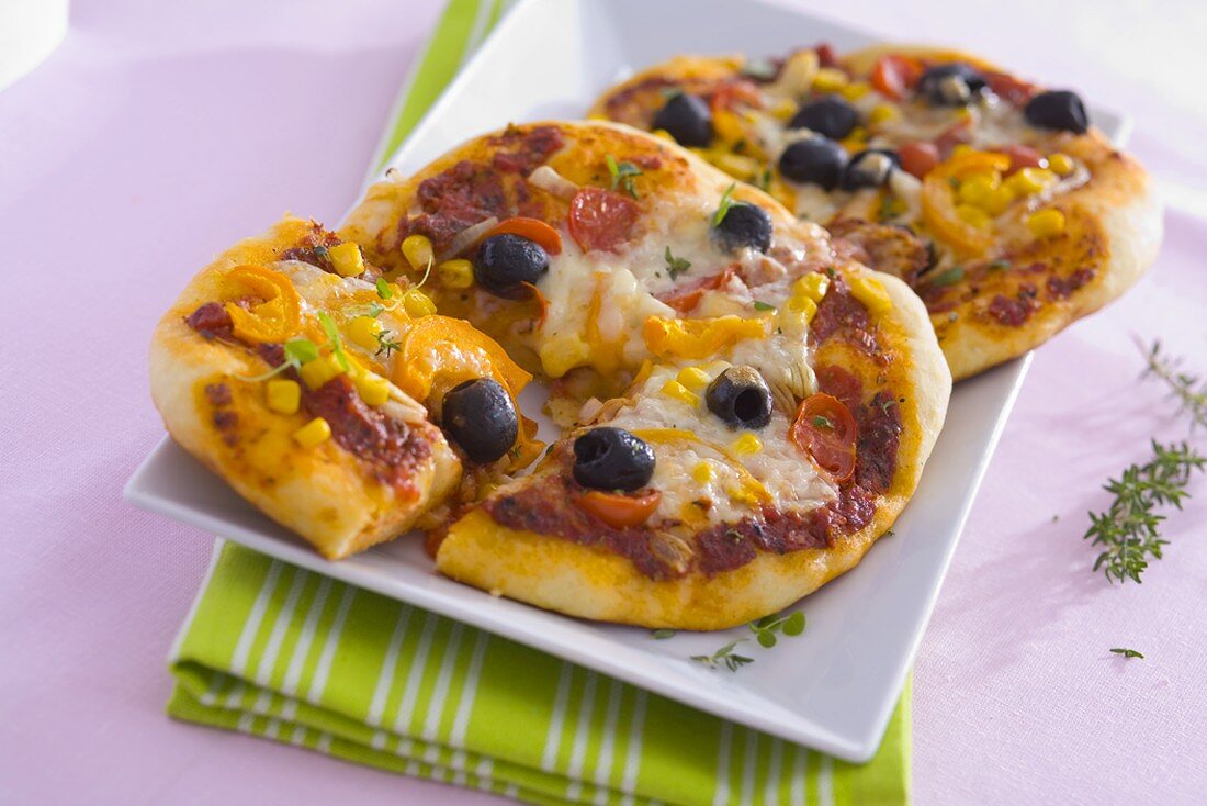 Two vegetable pizzas with sweetcorn and cheese