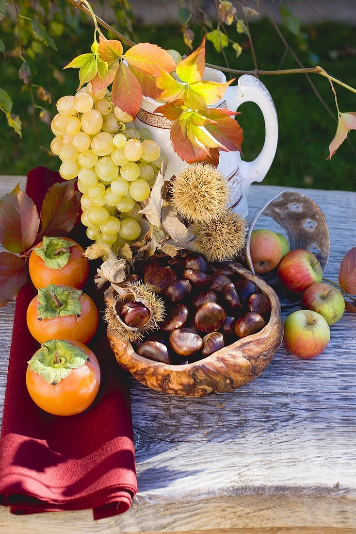 Esskastanien, Trauben, Kakis, Äpfel und Herbstlaub