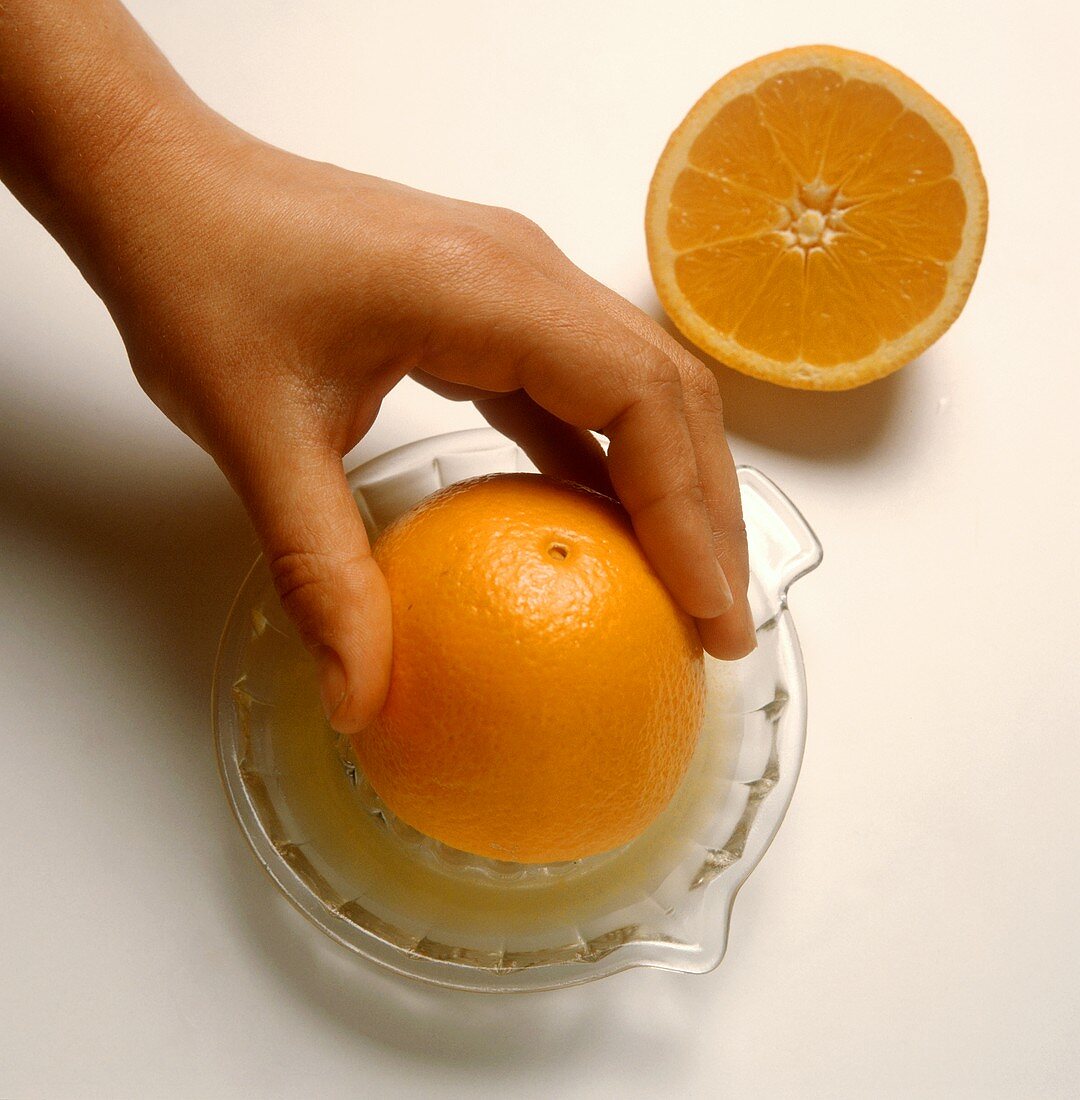 Orange von Hand mit Zitruspresse auspressen