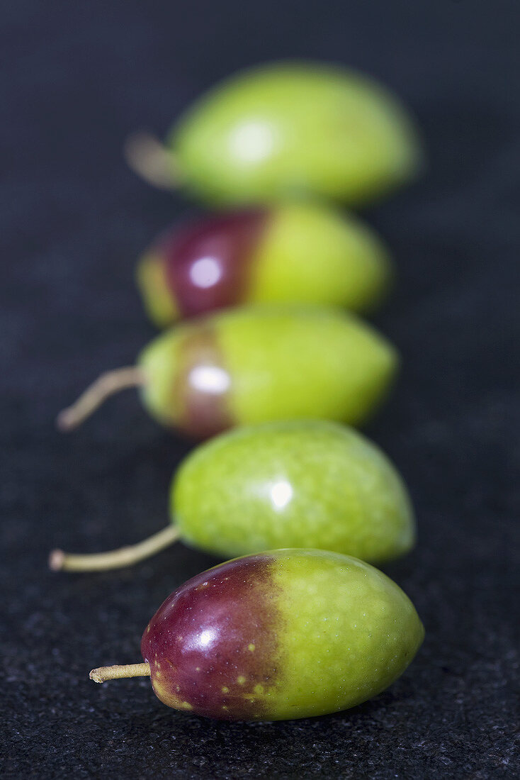 Five fresh olives in a row