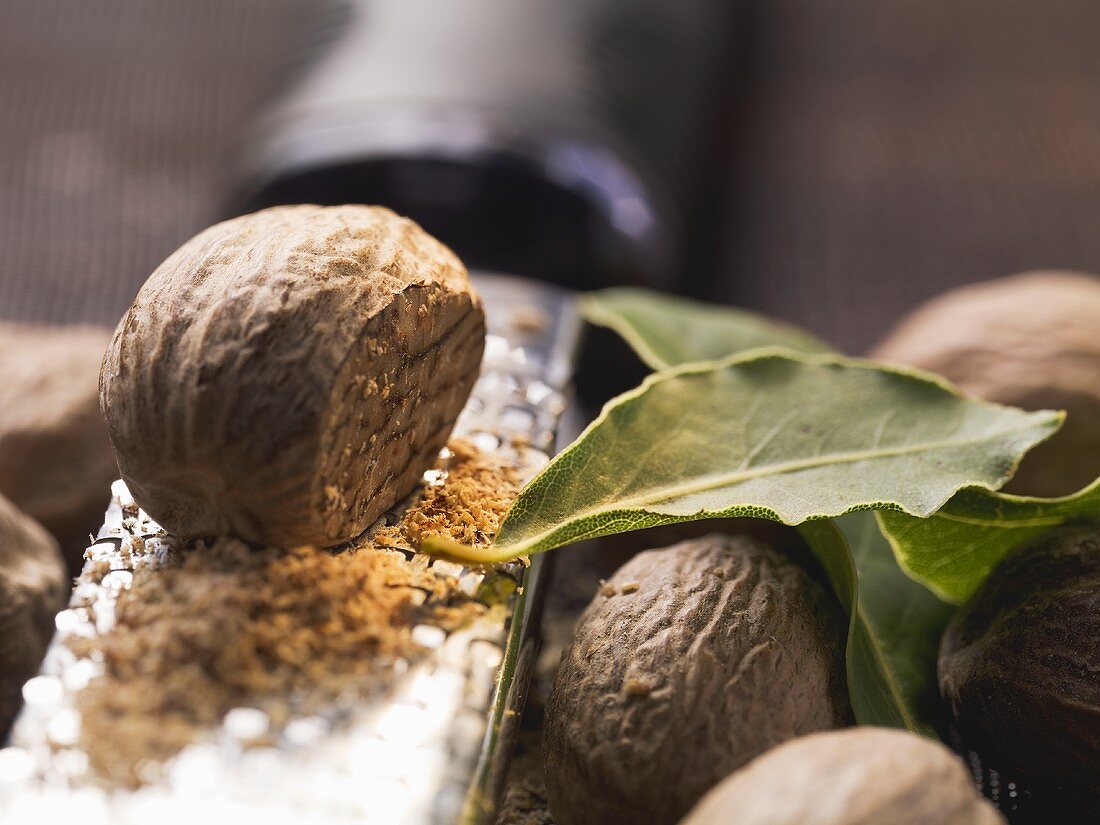 Nutmegs with grater and bay leaves