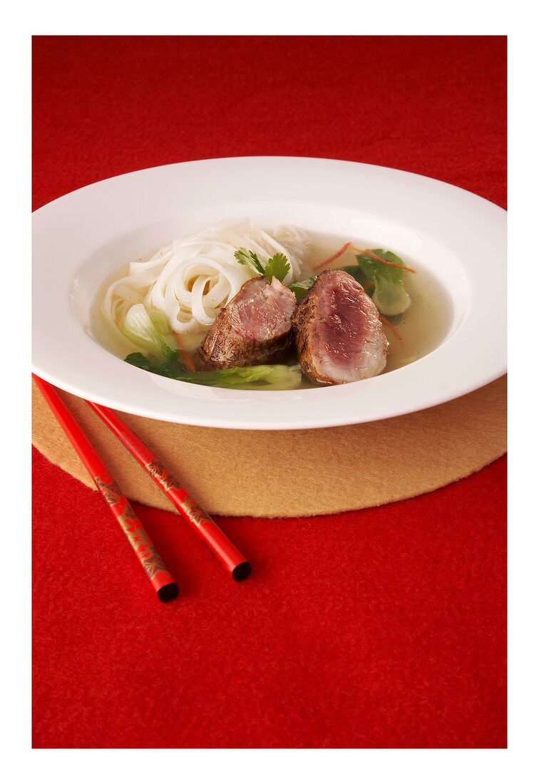 Thai broth with rice noodles and a pork fillet