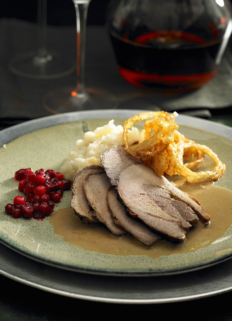 Wild boar with mashed potaoes, fried onions and cranberries