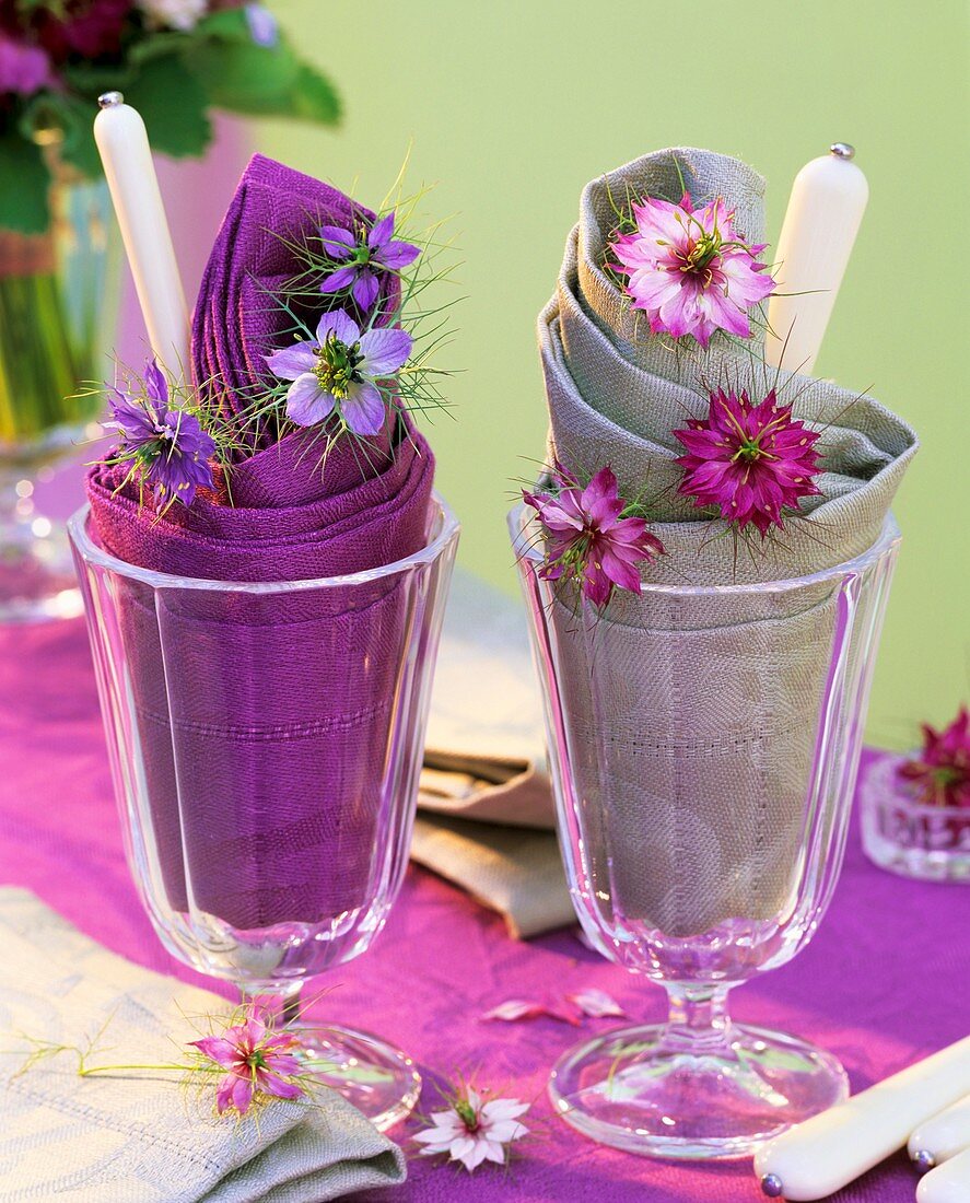 Napkins, cutlery and love-in-a-mist in sundae glasses