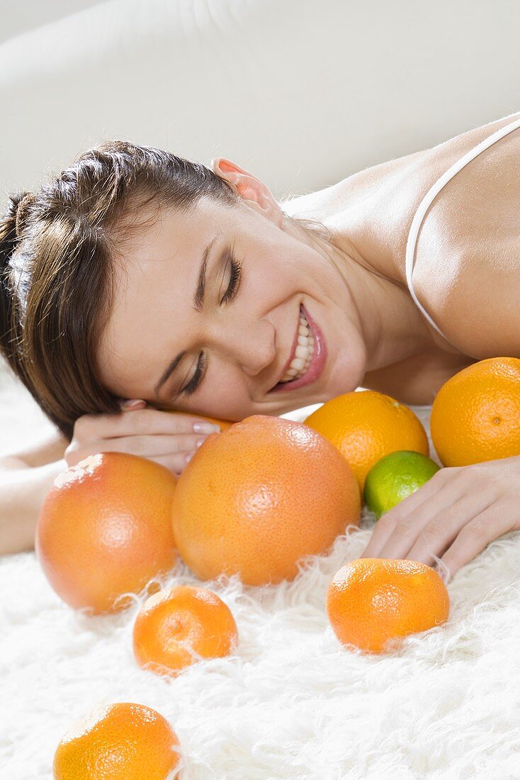 Young woman on a bed with citrus fruit