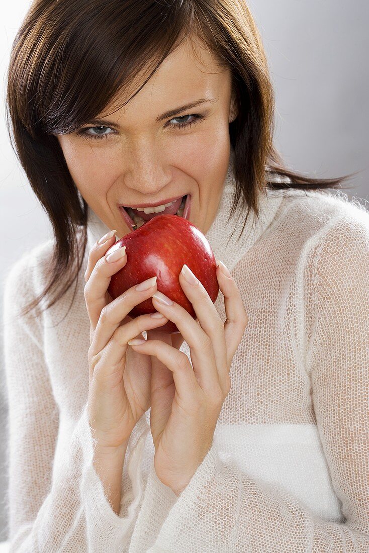 Young woman biting into an apple