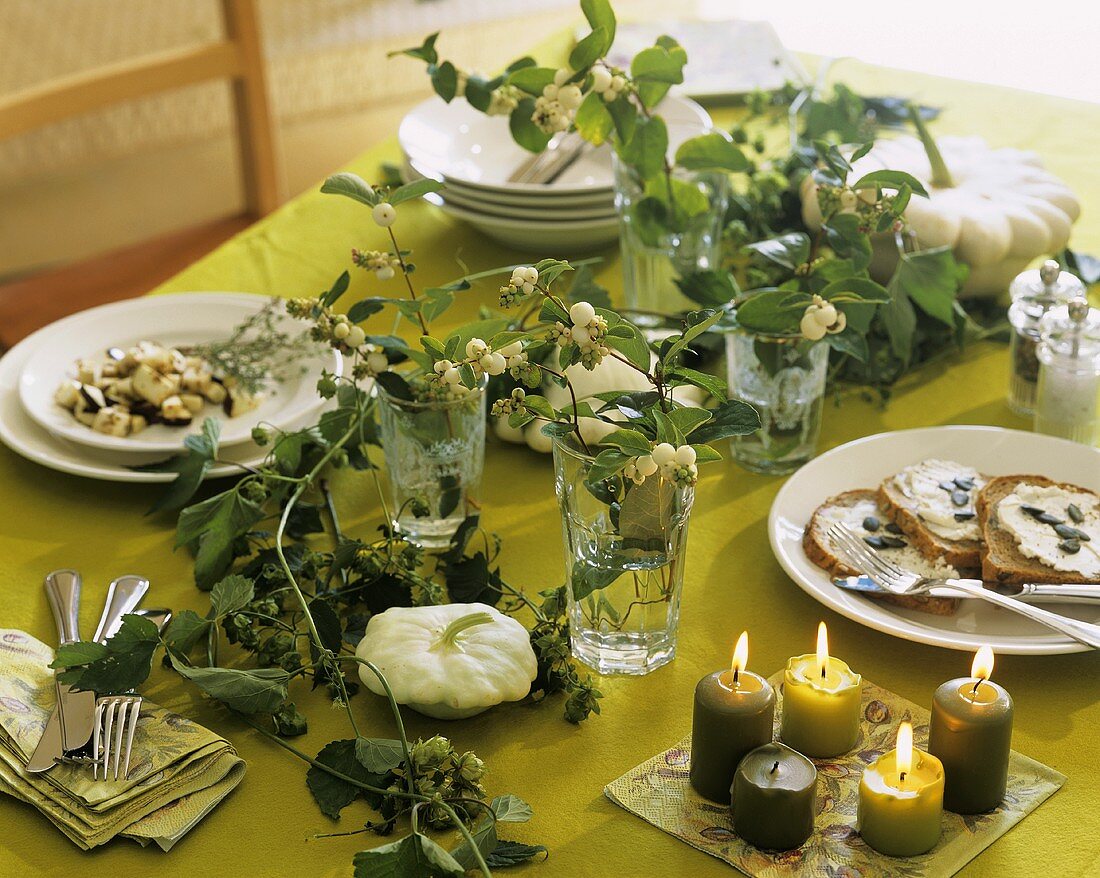 Table with autumnal decorations: snowberries, pumpkin, hops