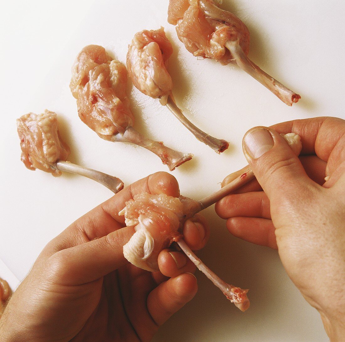 Preparing chicken wings (pulling the meat away from the bones)