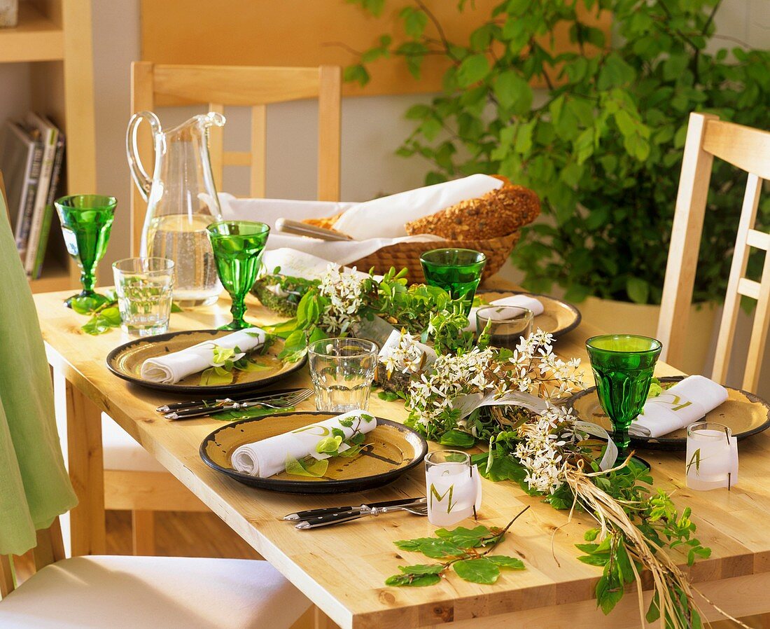 Gedeckter Tisch dekoriert mit Girlande aus Felsenbirne