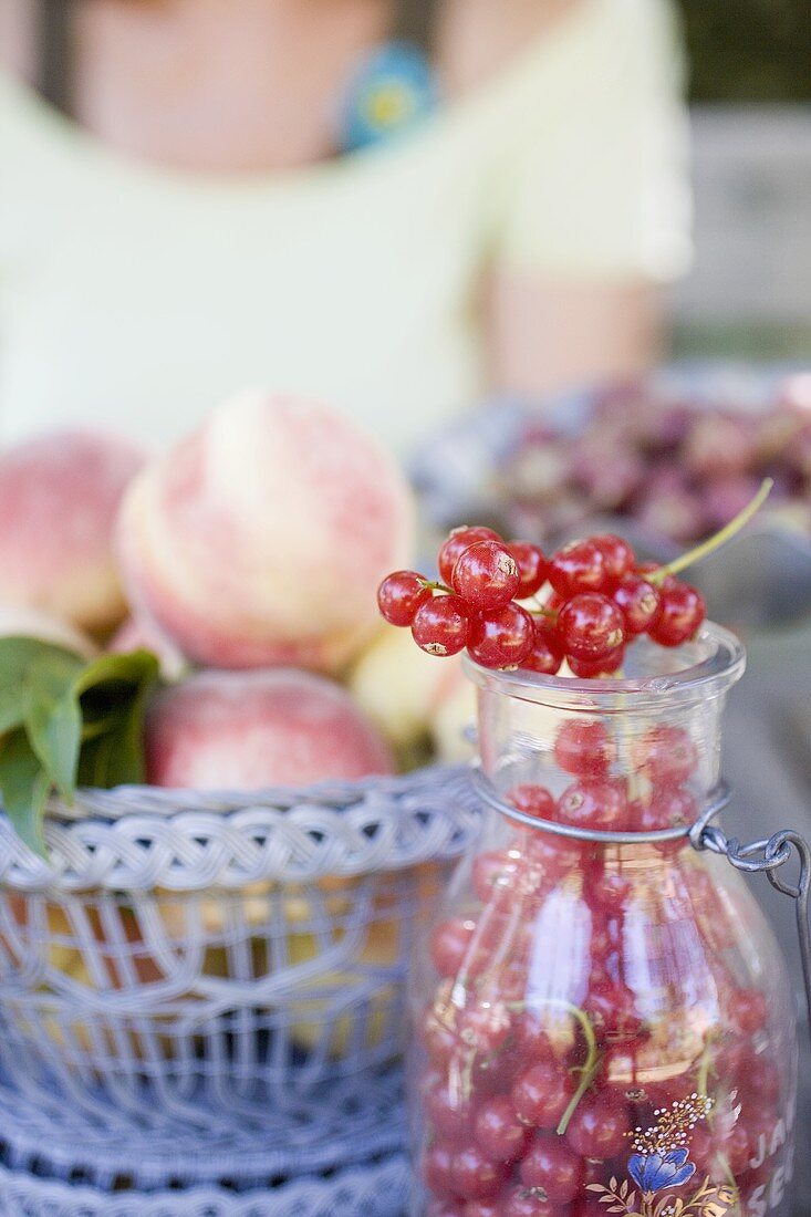 Rote Johannisbeeren und Pfirsiche auf einem Gartentisch