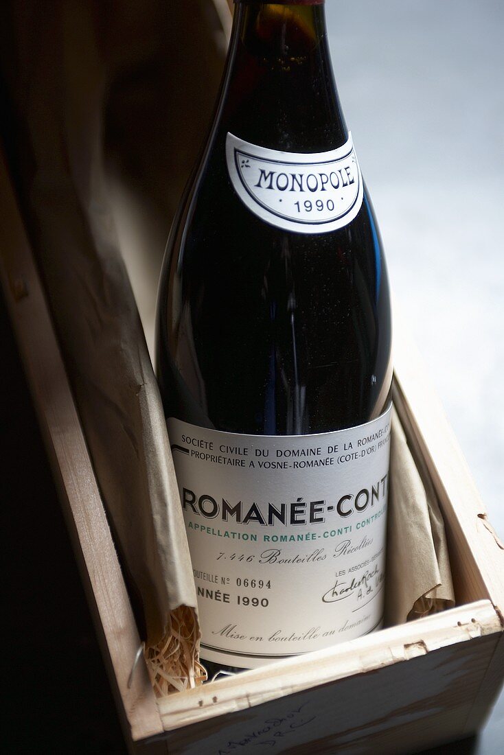 Bottle of red wine (Romanée-Conti, 1990 vintage) in wooden box