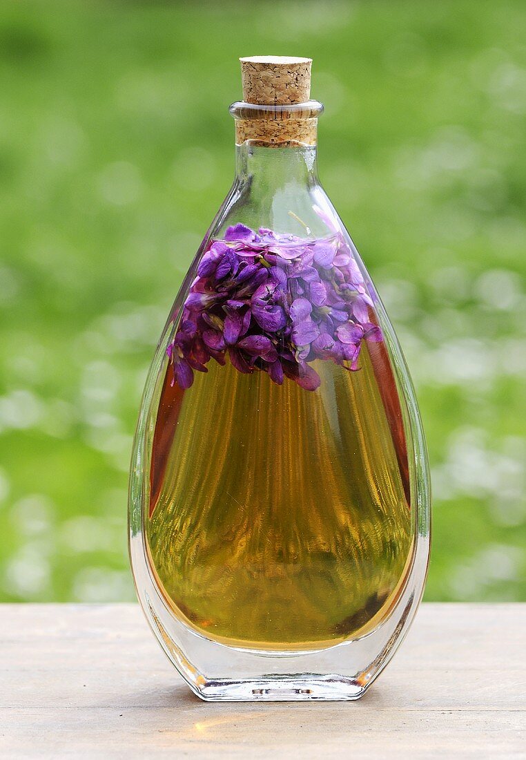 Sweet violets in bottle of oil
