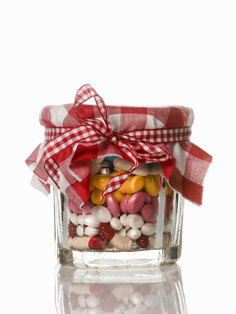 An assortment of tablets in a jam jar
