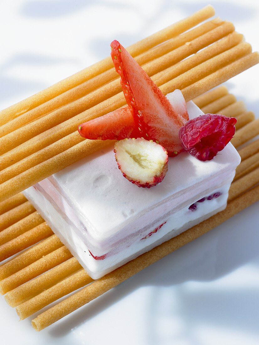 Ice cream dessert with berries and wafer rolls