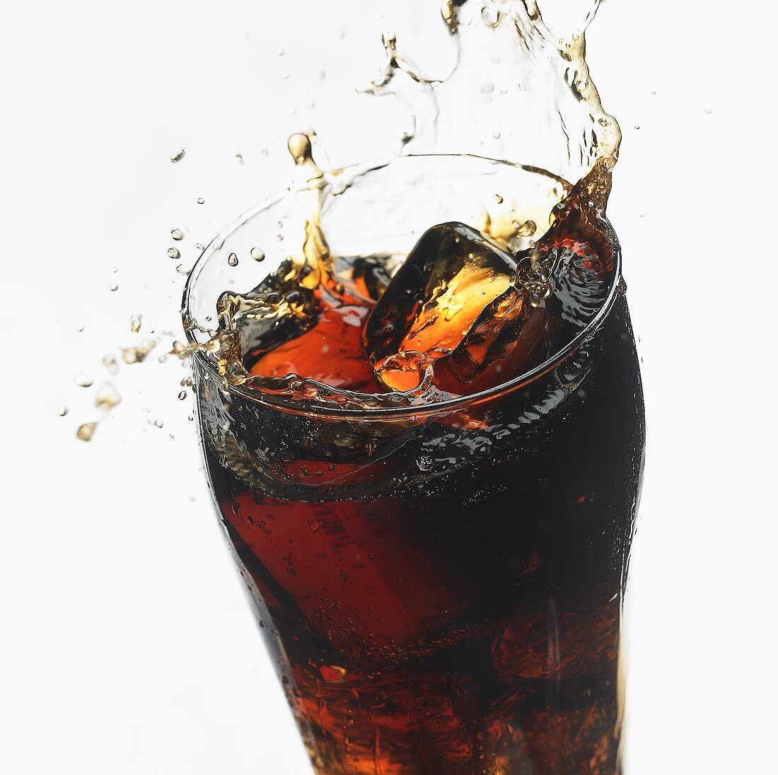 Eiswürfel fällt in Glas Cola