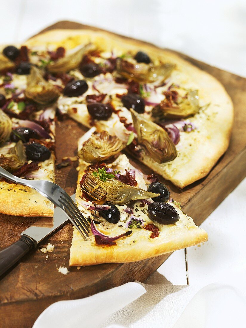 Pizza topped with artichokes, olives and onions
