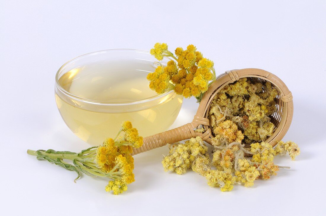 Cudweed tea in glass cup, flowers in tea strainer