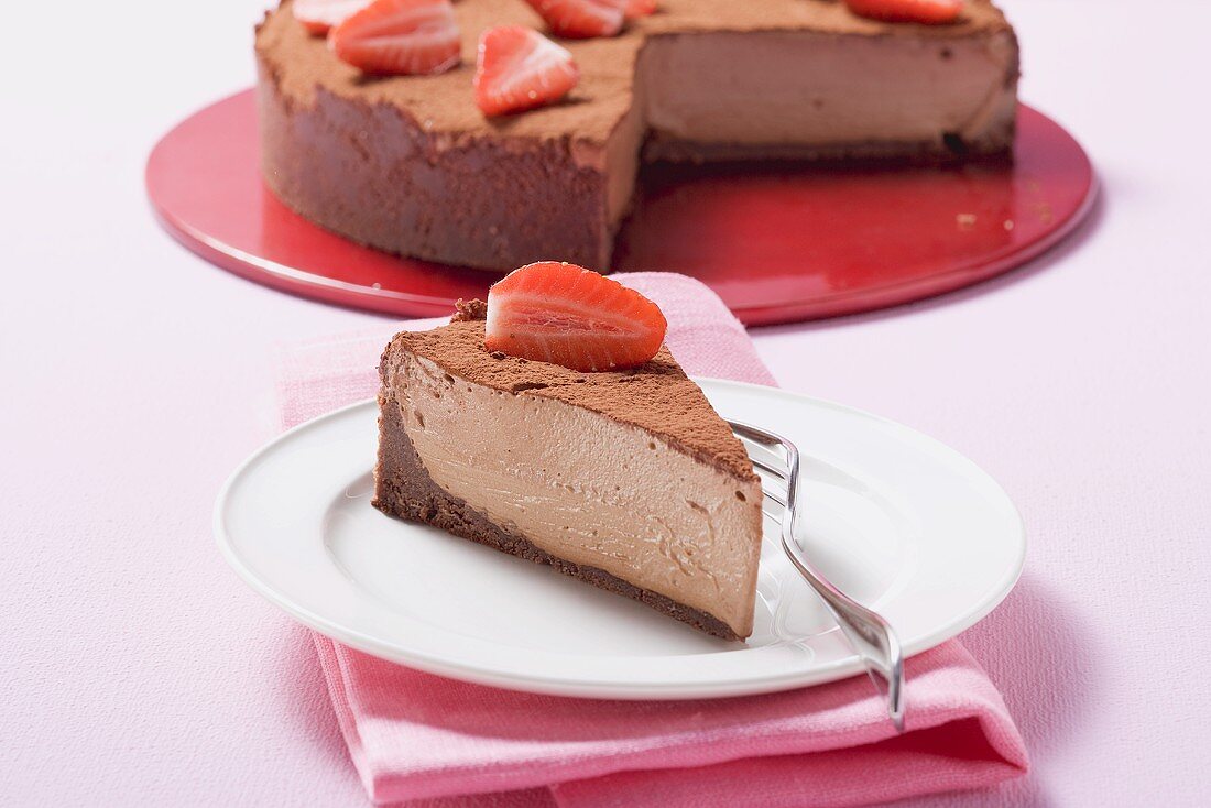 Schokoladenkäsekuchen mit Erdbeeren und Kakaopulver