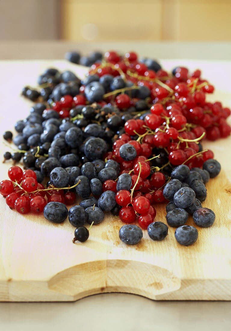 Red- and blackcurrants and blueberries on chopping board