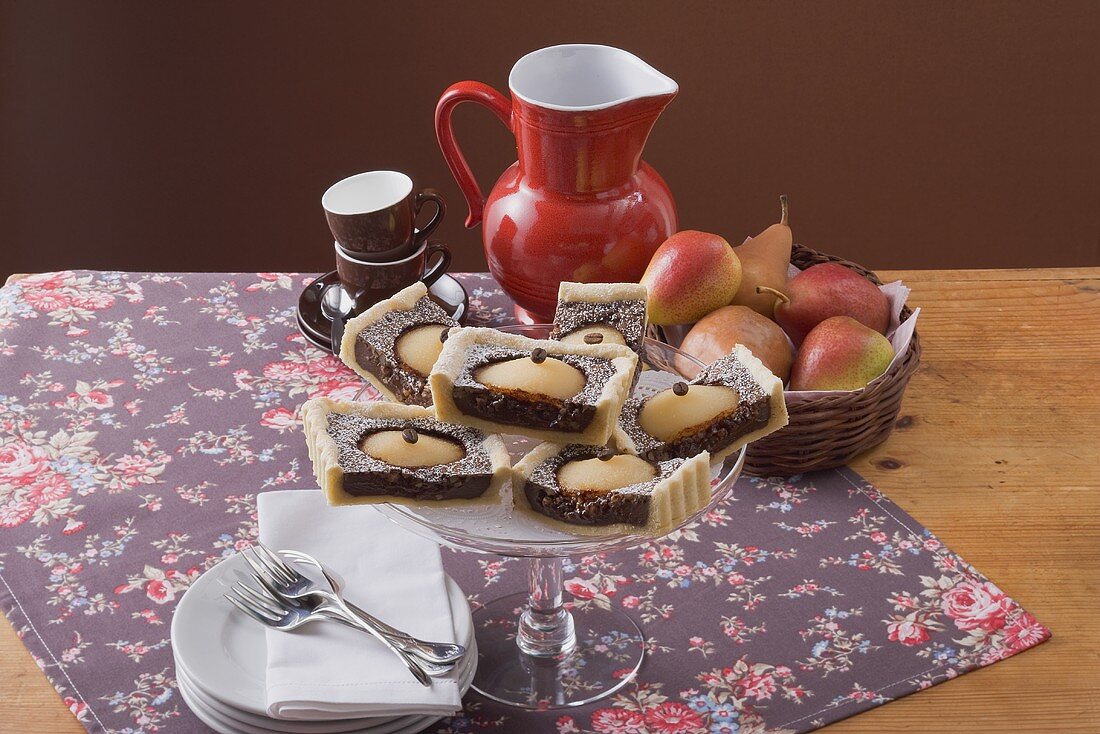 Mehrere Stücke Birnen-Schokoladen-Tarte auf Kuchenständer