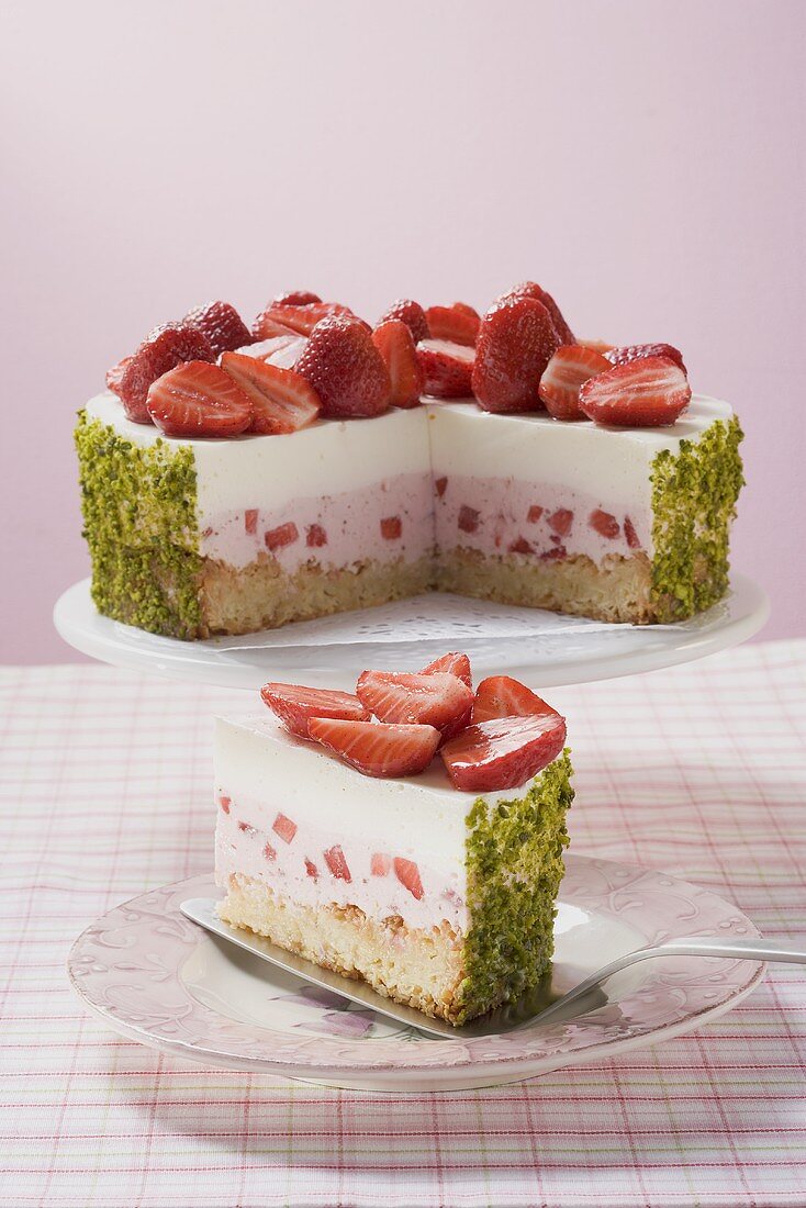 Strawberry yoghurt cake with pistachios, a piece cut