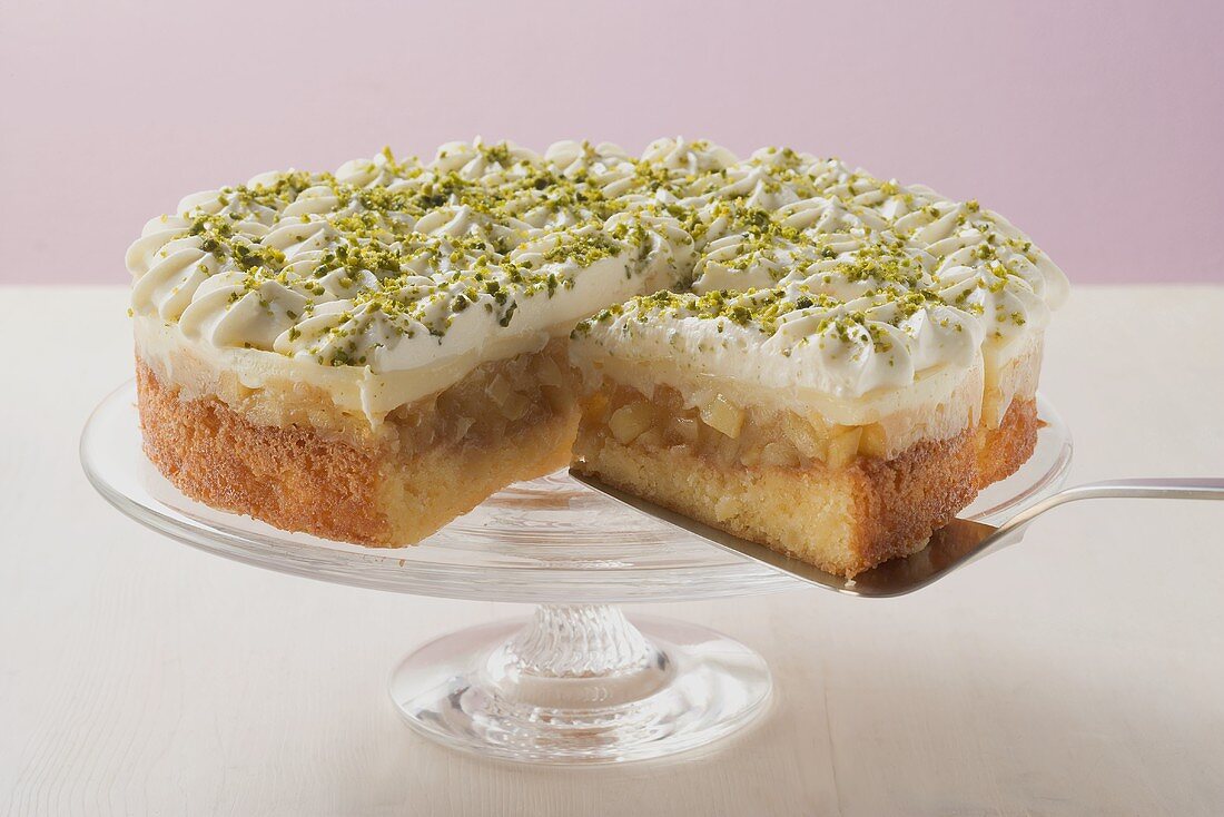 Apple cake with cream and pistachios, a piece cut