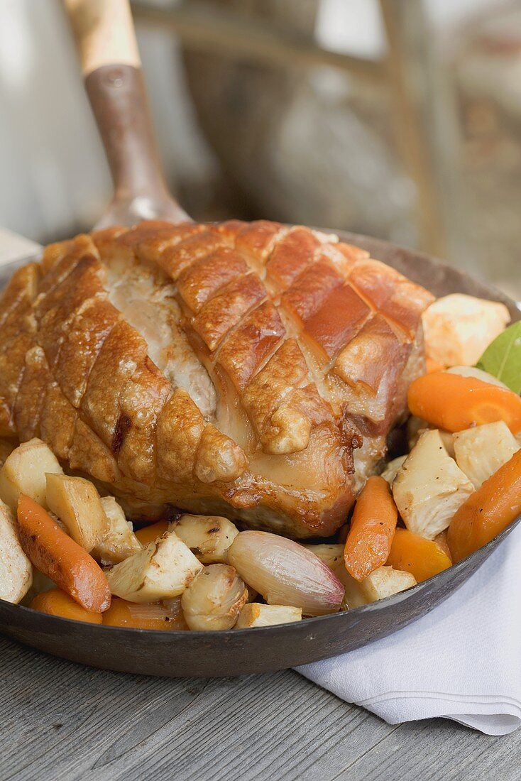 Roast pork with root vegetables in a frying pan