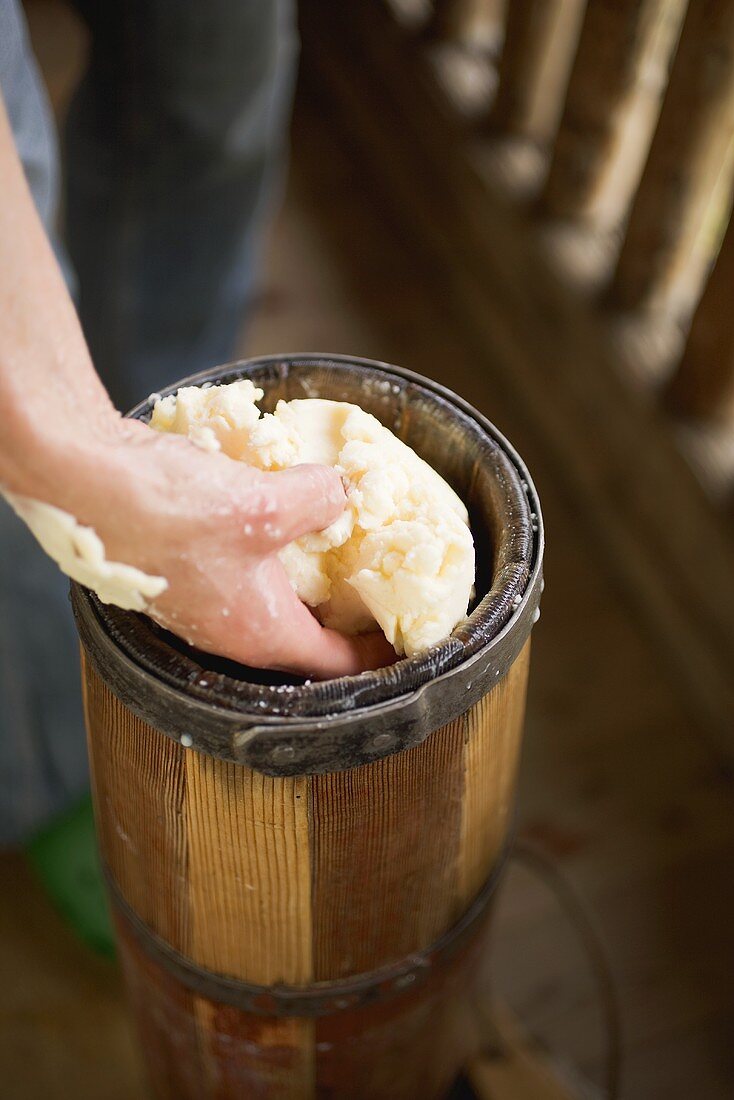 Hand taking butter out of churn