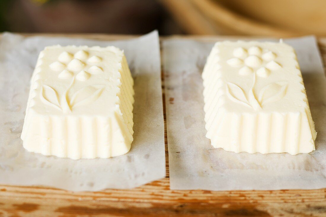 Blocks of butter shaped in wooden moulds on paper