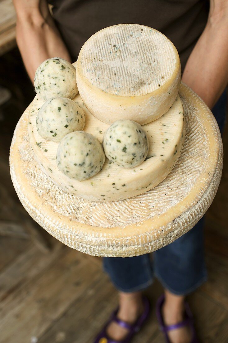 Woman holding various cheeses