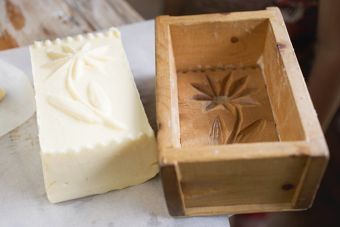 Butter with flower design beside wooden mould