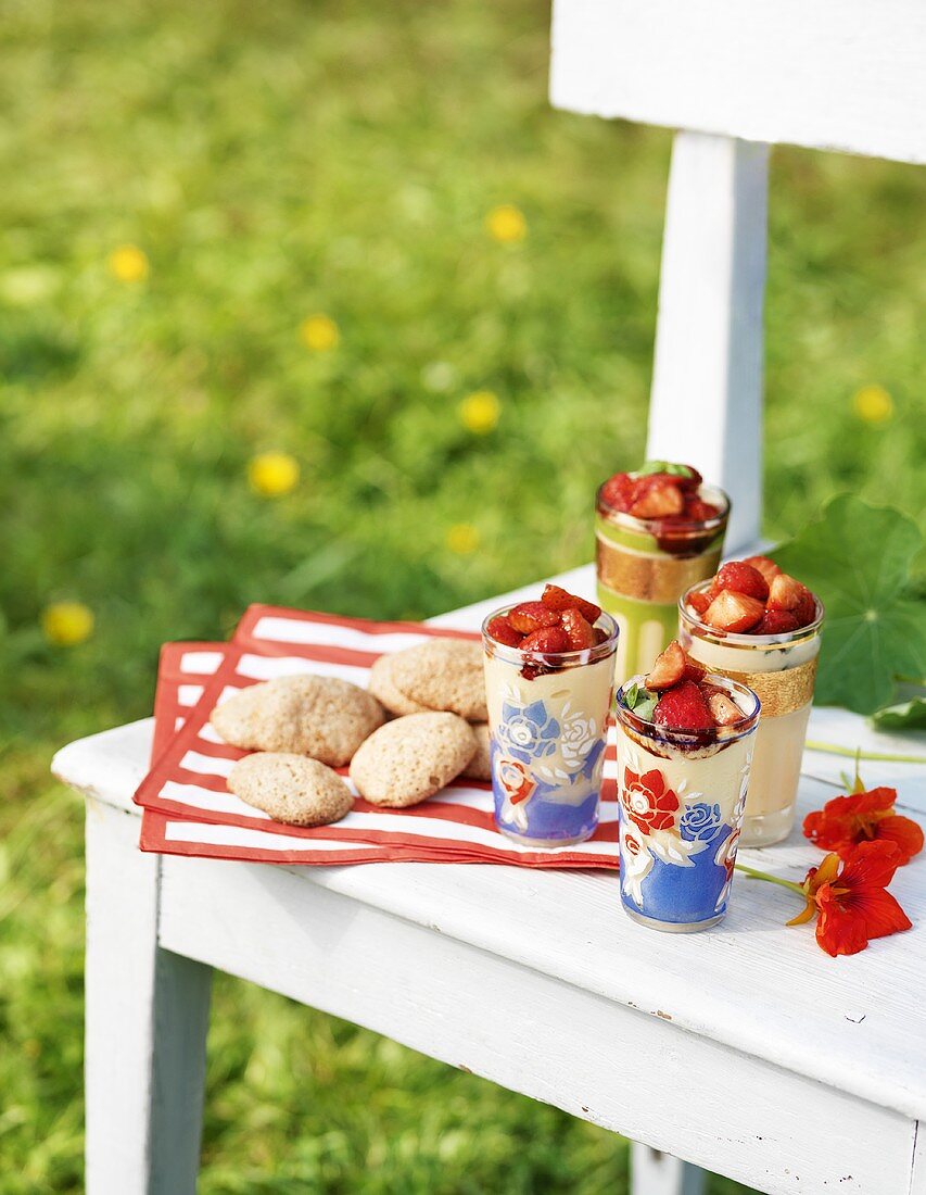 Cookies und Erdbeerdesserts auf Holzbank im Freien