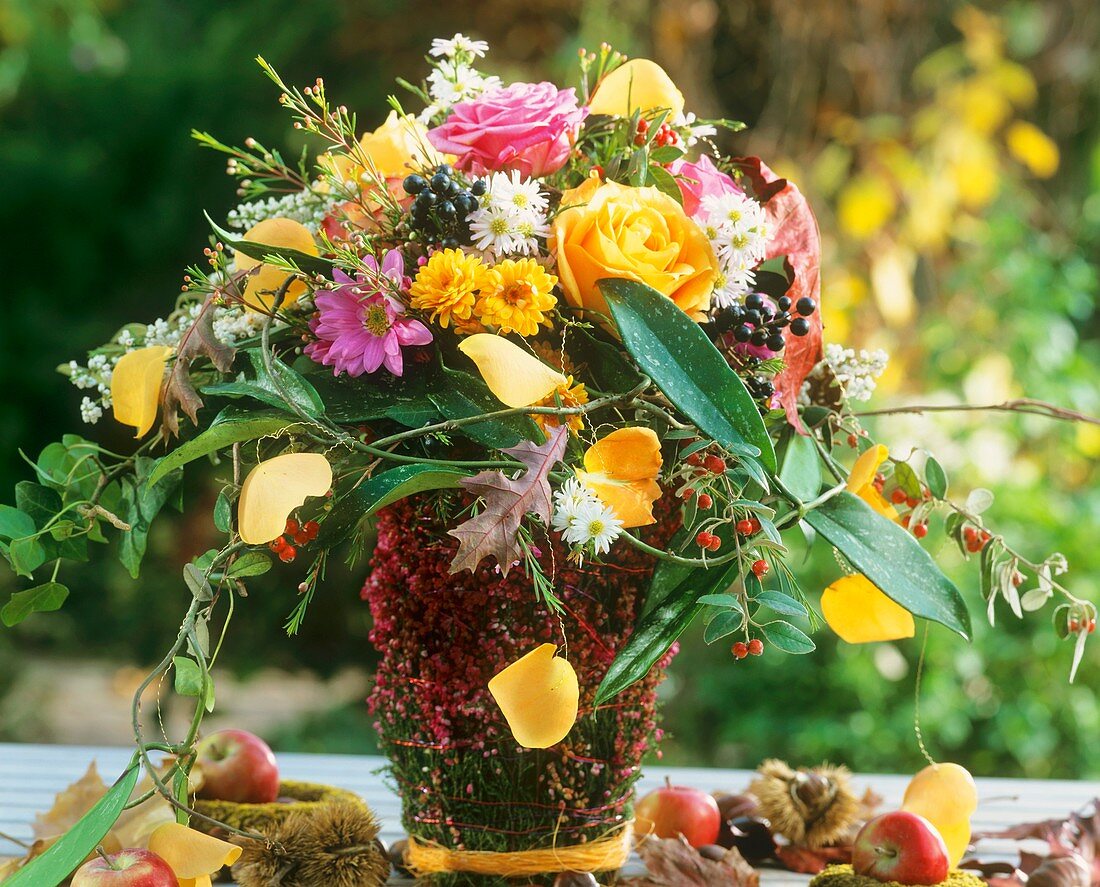 Herbststrauss im Topf mit Callunablüten umwickelt