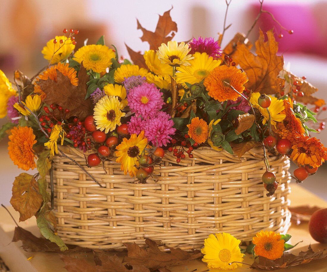 Körbchen mit Hagebutten, Ringelblumen und Chrysanthemen