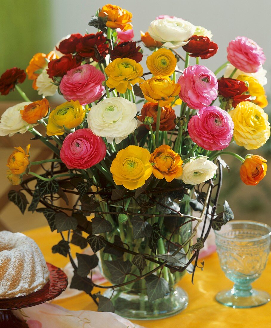 Arrangement of Ranunculus and ivy, mini-gugelhupf beside it