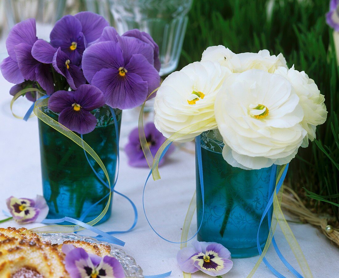 Pansies and Ranunculus in blue glasses