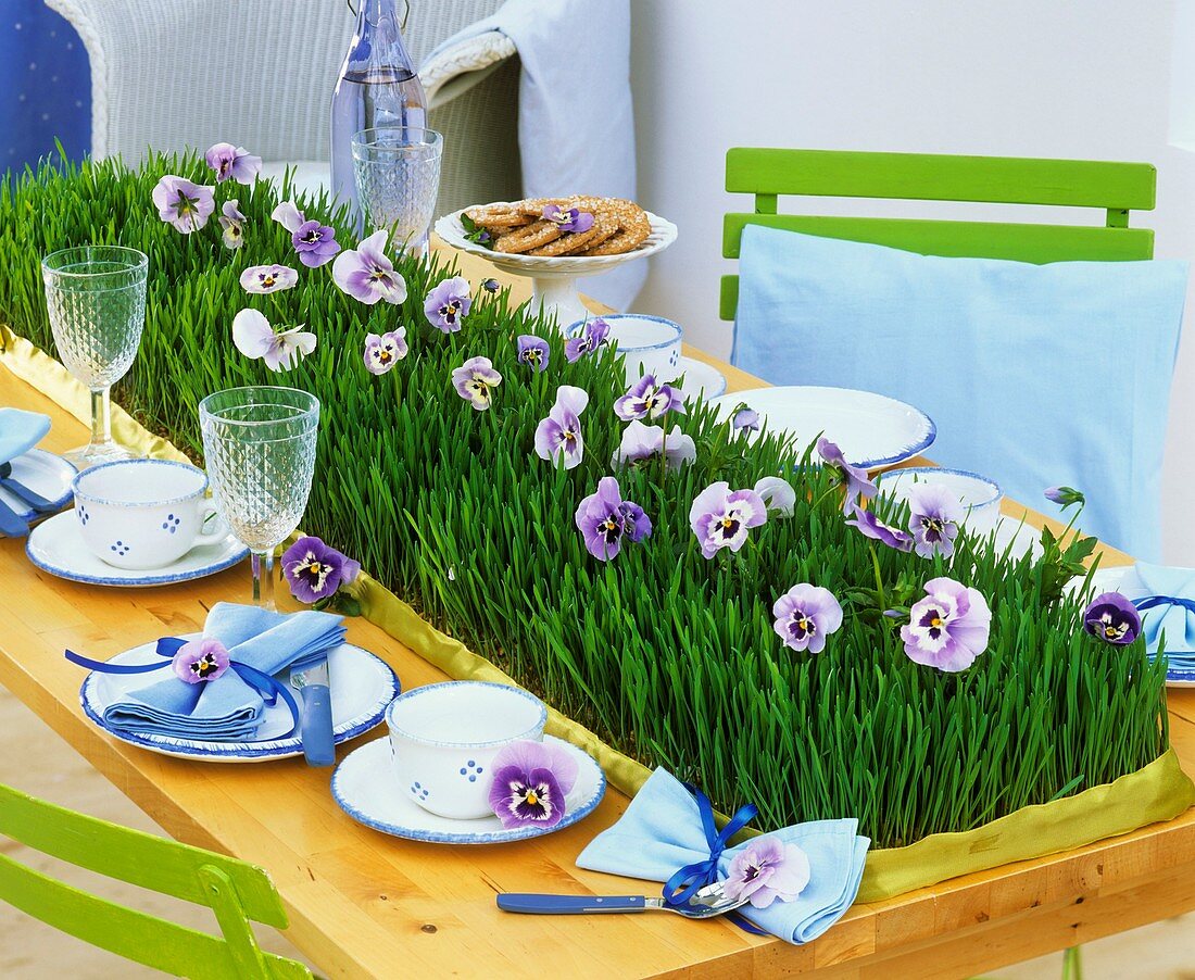 Table runner of wheat grass & pansies on table laid for coffee