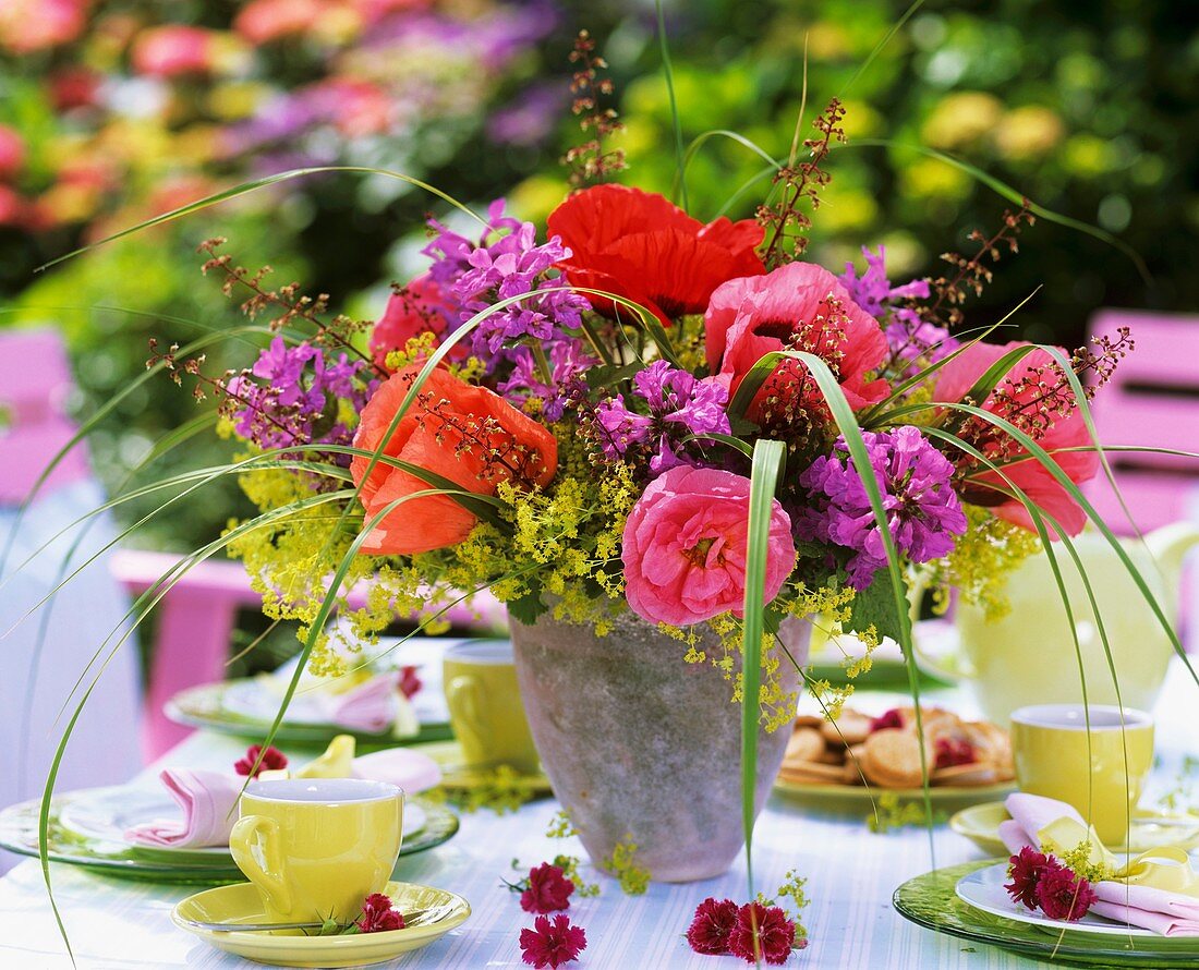 Strauß aus Mohnblüten, Frauenmantel, Ziest und Purpurglöckchen auf Kaffeetisch