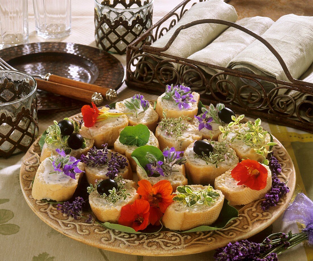 Baguette appetisers with herb leaves and flowers