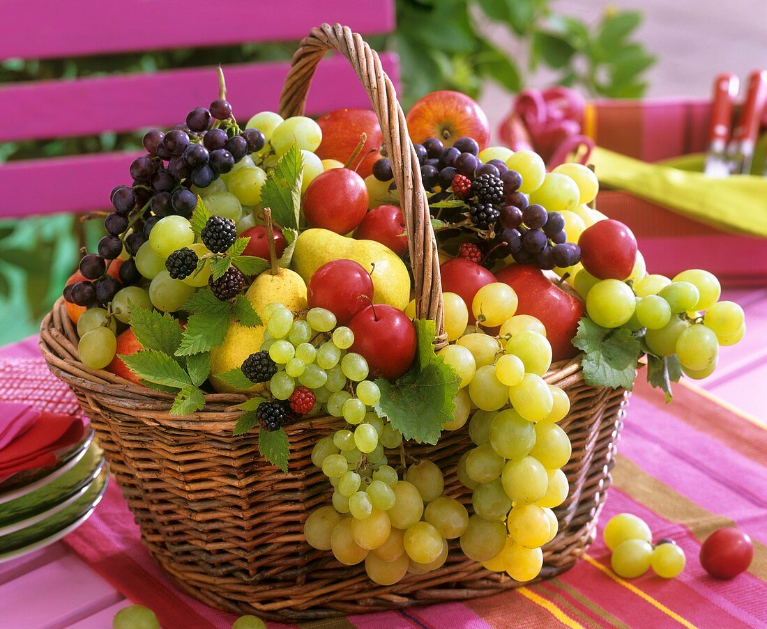 Obstkorb mit Weintrauben, Pflaumen, Brombeeren und Birnen