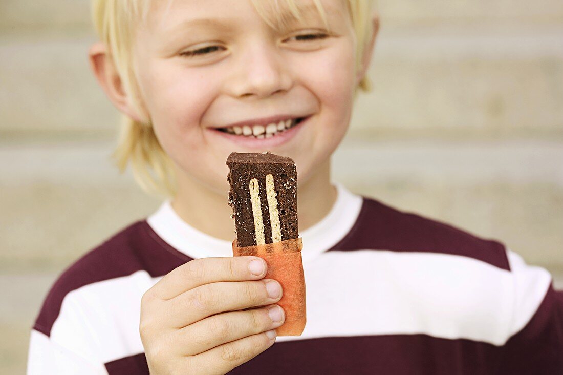 Boy eating Ischokladkaka (Chocolate biscuit cake, Sweden)