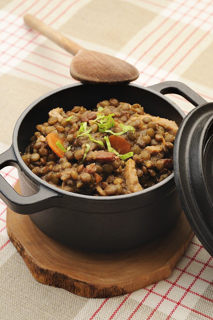 Lentil stew with bacon in pot