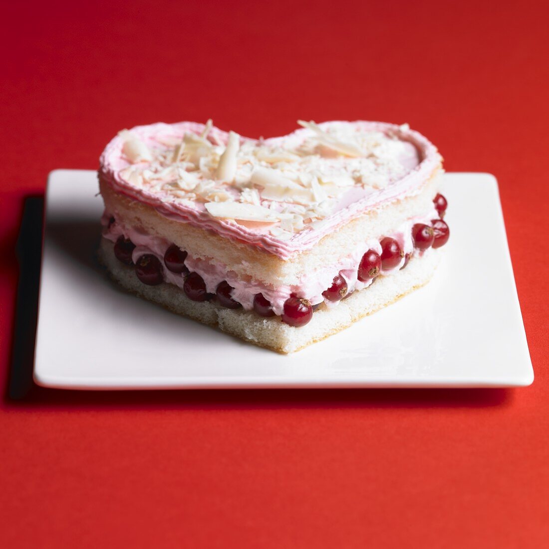 Heart-shaped sponge cake with redcurrants and cream