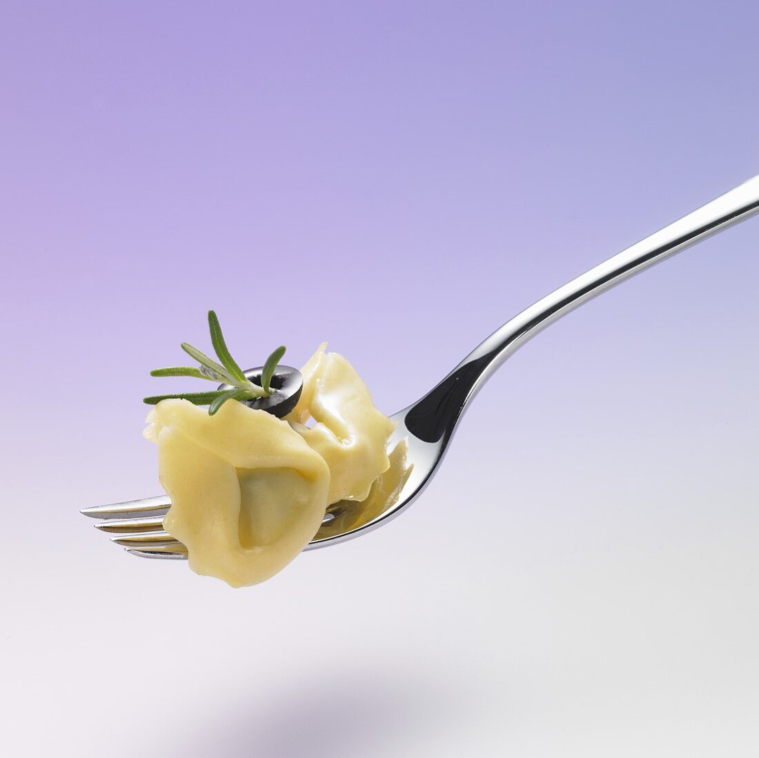 Tortellini with rosemary and olive on a plate