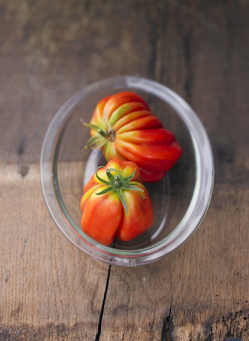 Two tomatoes in glass dish
