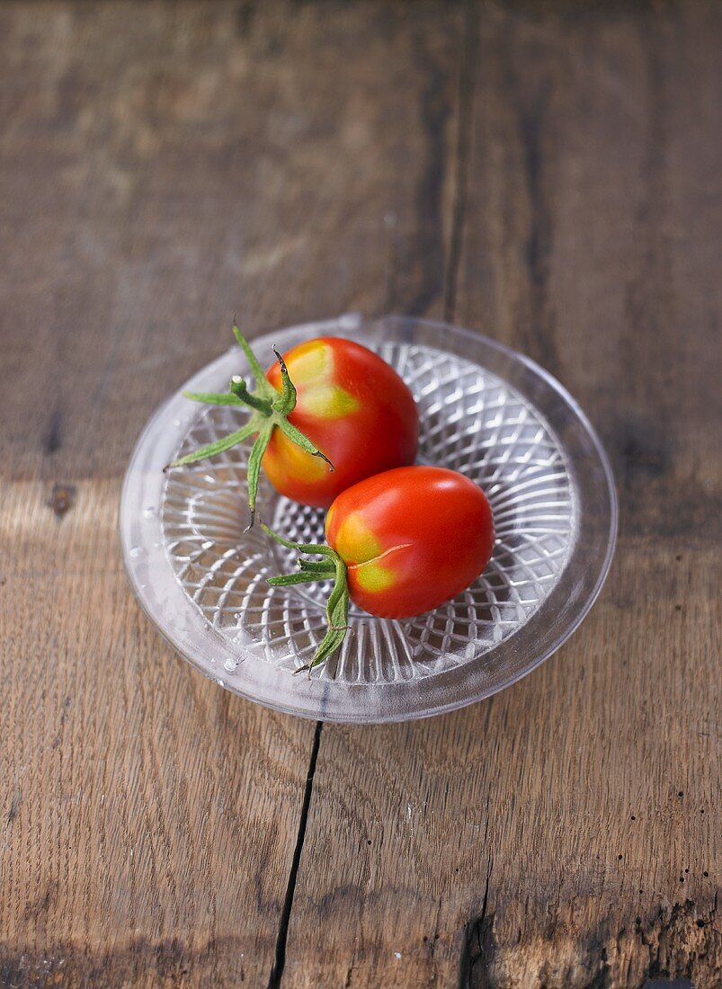 Zwei Tomaten der Sorte Omas Beate auf Glasteller