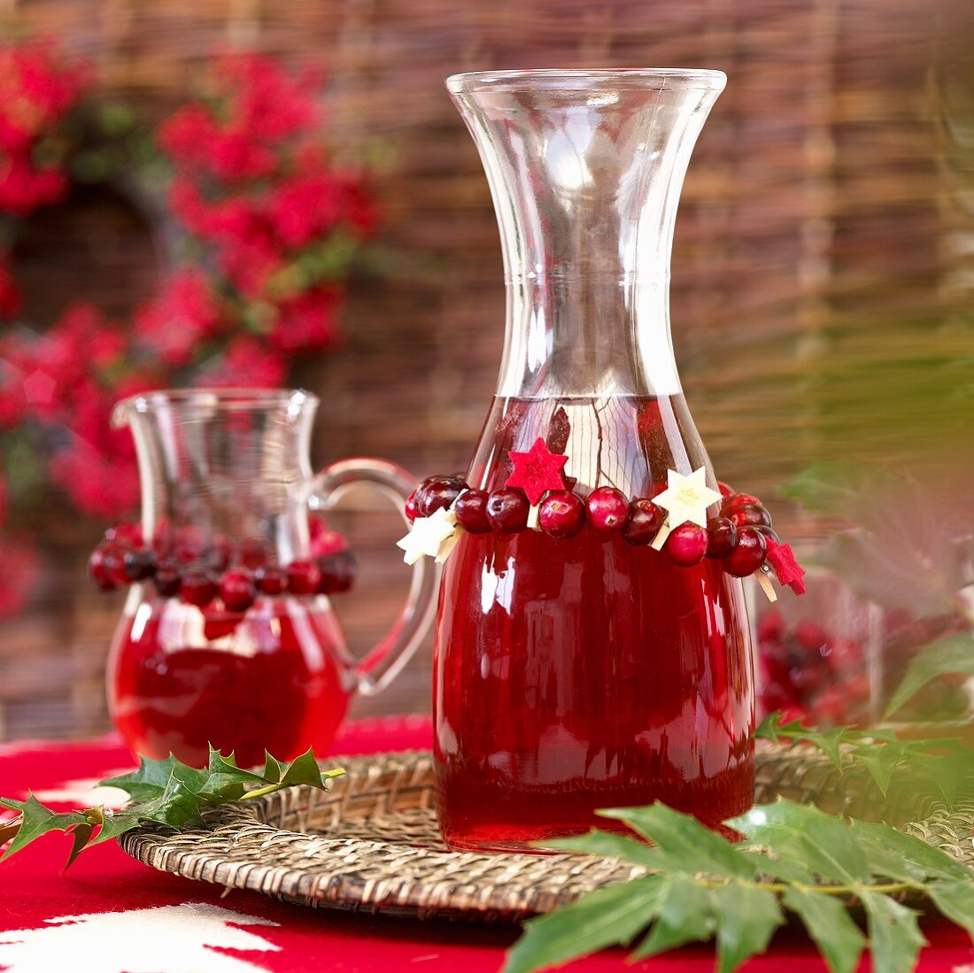 Cranberrysaft in Karaffe und Glaskrug (weihnachtlich)