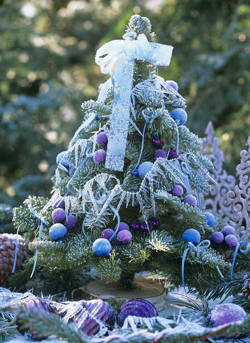 Small decorated Christmas tree with hoar frost