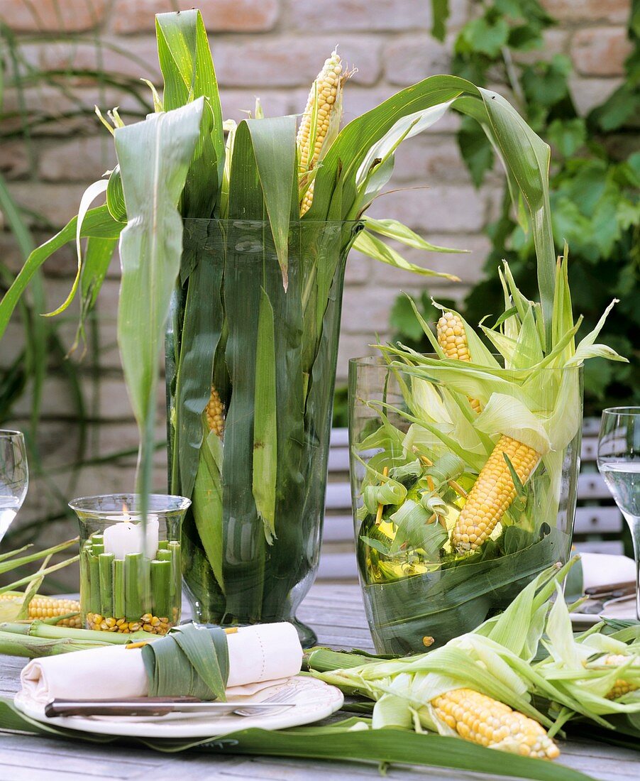 Table in open air decorated with corncobs and maize leaves