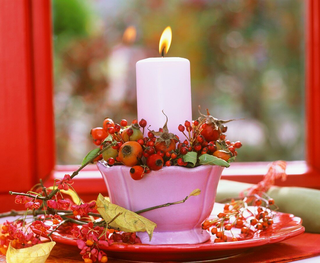 Candle holder with rose hips and spindle berries